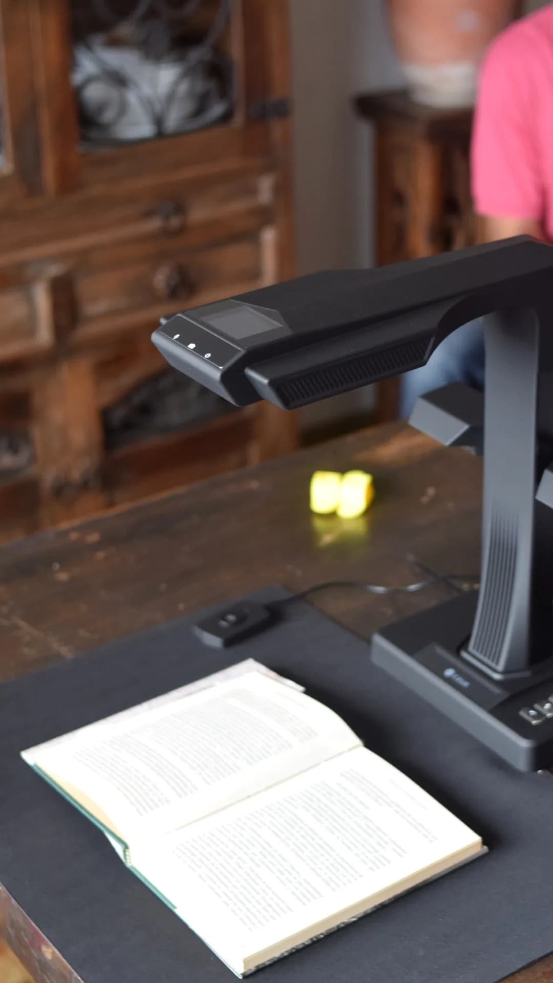 Escáner cenital CZUR de TUDIGI sobre una mesa de madera, con un libro abierto listo para escanear